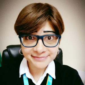 Hope Aguilar, ovarian cancer survivor, smiles with an inquisitive look.